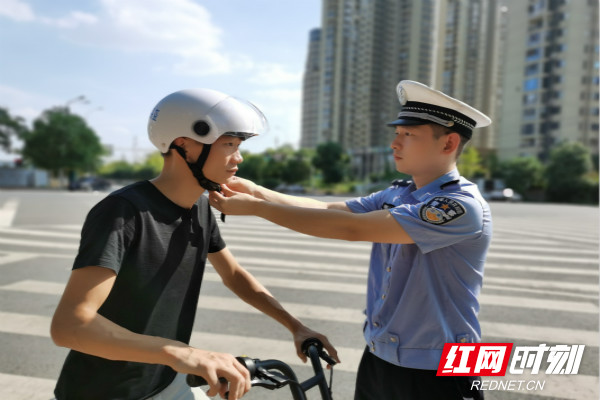 芙蓉交警大队民警民警王琼为共享电动车驾驶员佩戴头盔。_meitu_2.jpg