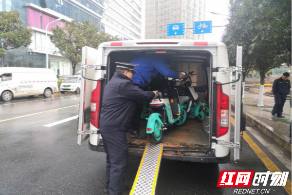 芙蓉区行政执法人员跟企业工作人员一起搬运无牌照共享单车。_meitu_1.jpg