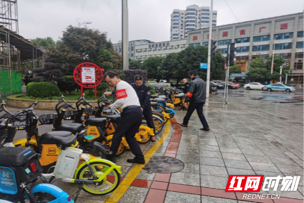 五一大道赛格数码广场执法工作人员和志愿者正在清理共享单车。_meitu_3.jpg