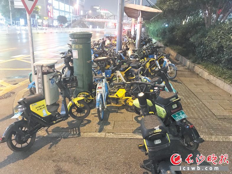 　　有牌和无牌共享电单车把公交车站围成了一个孤岛。长沙晚报全媒体记者 吴鑫矾 摄