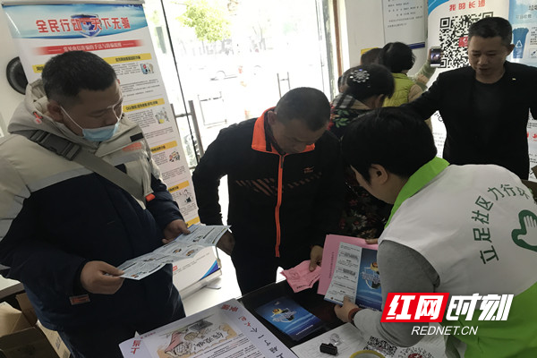 志愿者向居民发放防诈骗宣传手册.jpg