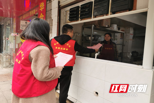 志愿者向早餐店发放倡议书.jpg