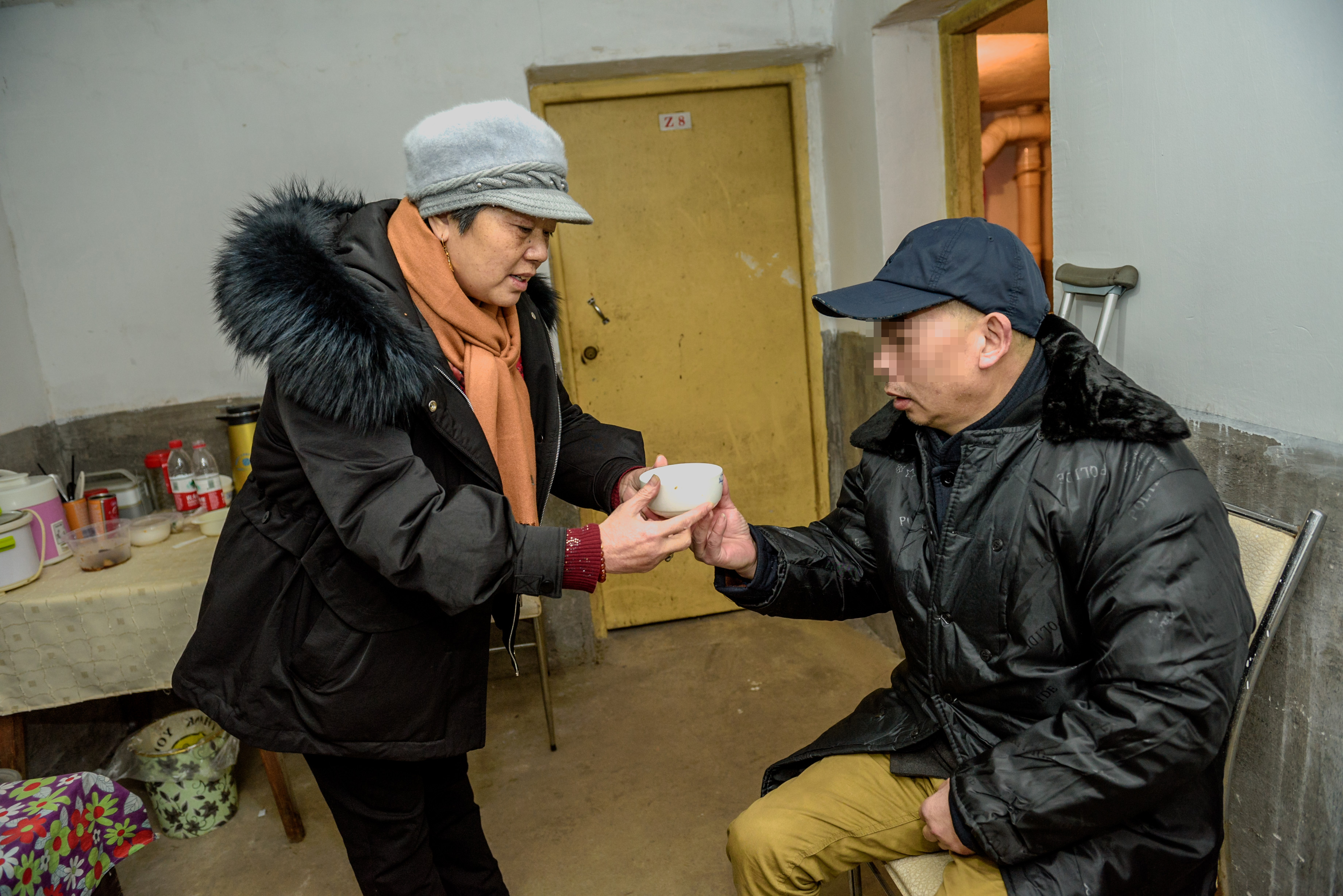 邻居翁大姐给老秦送来热汤。 全媒体记者 陈飞 摄