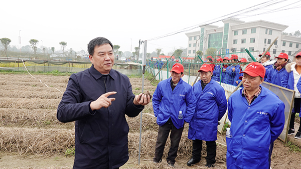 湖南省劳动模范邓述东（左）在田间地头指导贫困户种植技术。.jpg