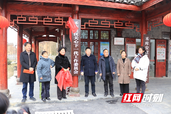 州关工委办公室主任覃占波同志和县关工委执行副主任洪金玉同志为禾库社区成立关工委揭牌。.jpg