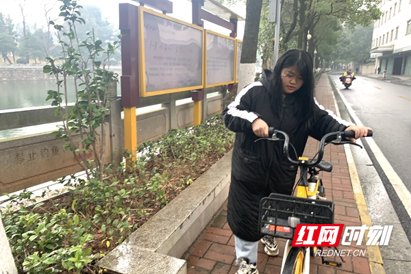 “99后”喻周盼正在辖区巡察，处理共享单车乱停放问题.jpg