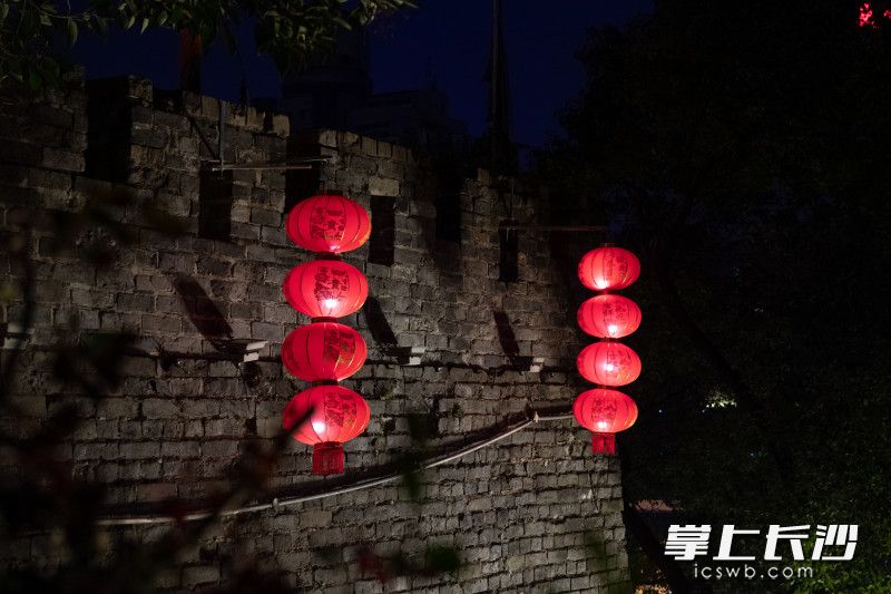大红灯笼挂在古城墙前韵味十足。