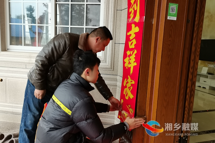李雪锋和儿子一起贴春联。.jpg