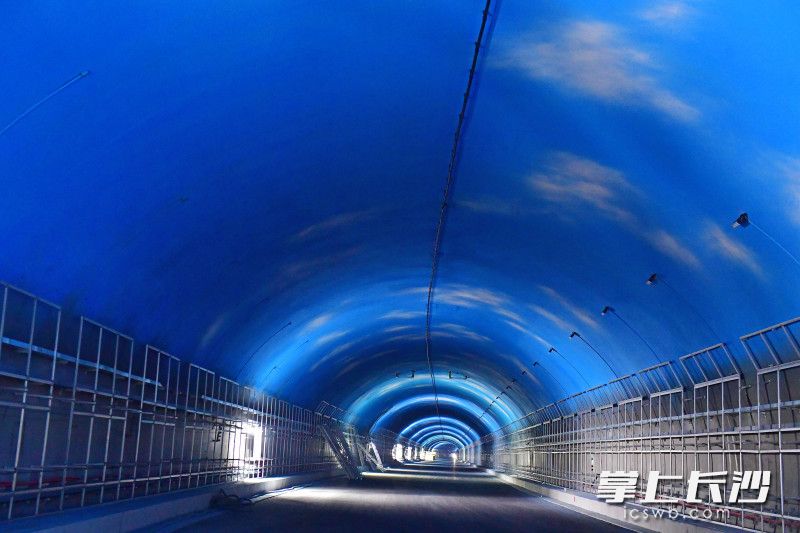 目前，麓景路南延线工程隧道顶部蓝天白云彩绘已喷涂完毕，正在进行防护板、机电安装等扫尾施工，预计今年6月实现完工。均为长沙晚报记者 王志伟 摄