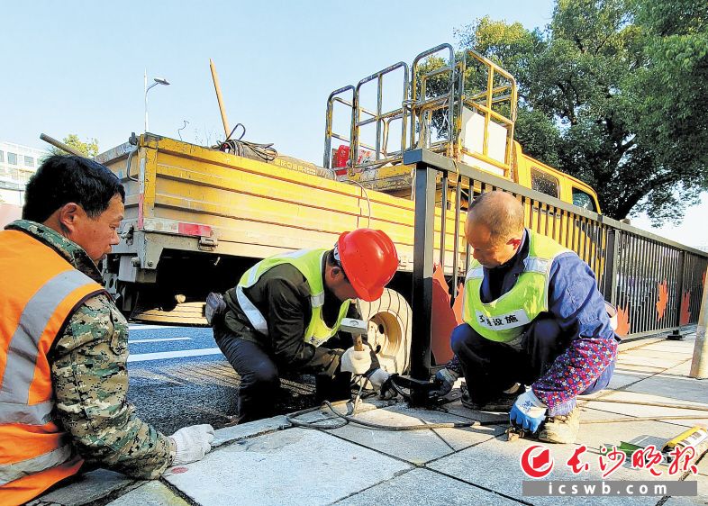 　　市政工人正在修补人行道上的破损路面，保障通行安全。　　吴峰荣 摄