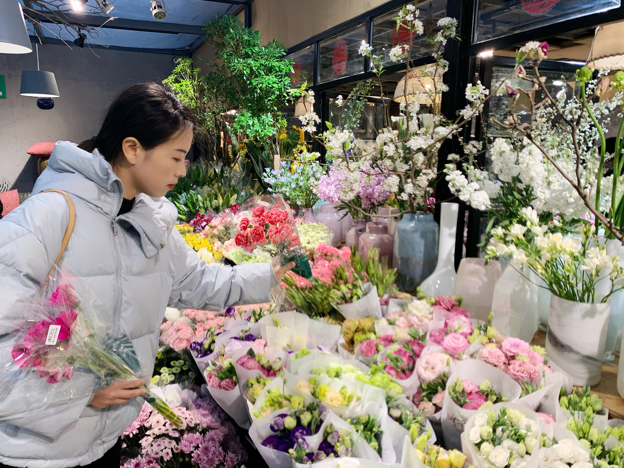 在三湘花卉市场的都市花乡，各种鲜花姹紫嫣红，市民正在选购。