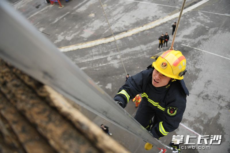 消防员攀爬15米金属拉梯，迅速到达“救援地点”。
