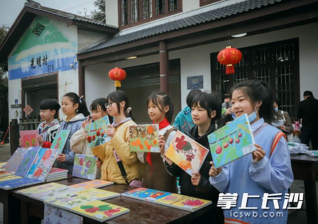 论坛会场外，光明小学的孩子们展示自己的油画作品。