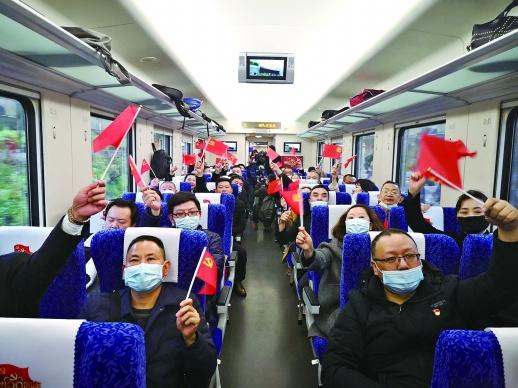 3月19日，乘坐首趟湘赣边红色专列的党员们挥舞红旗，高唱红歌。.jpg