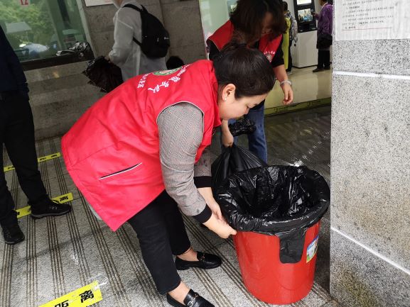 森林公园鸽子花志愿服务队员清扫垃圾，为游客营造一个舒适的购票环境（张新民摄）.jpg