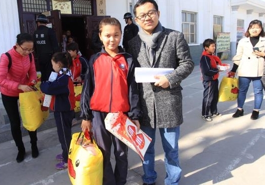 周永亮（前排右一）前往阿曼夏学校看望对口帮扶点孩子。 受访者供图