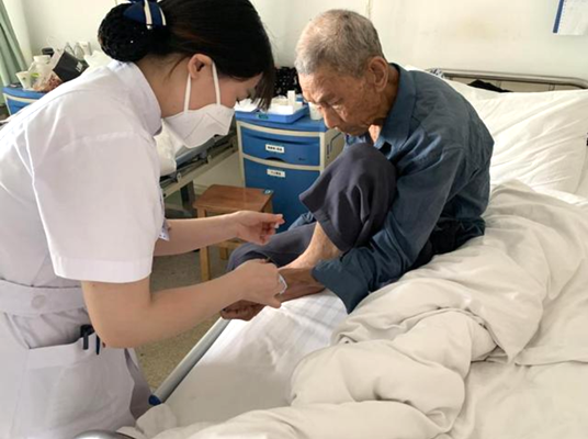 5月7日，新田县金盆镇卫生院护士温艳琼在为住院患者擦药。.png