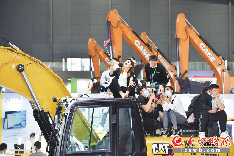 年轻人在展出的工程机械上玩自拍玩直播,乐在其中。 长沙晚报全媒体记者 王志伟 摄