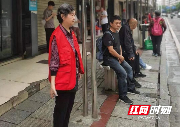 党员志愿者在公交车站引导文明出行.jpg
