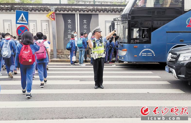 　　护学岗交警指挥交通。　　长沙市公安局供图