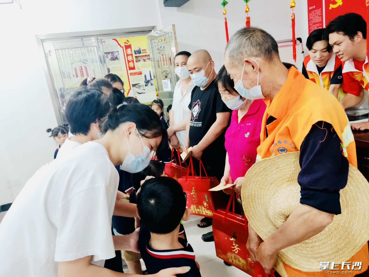 党员志愿者和亲子家庭一起将“廉心粽”礼包送给社区困难居民、环卫工人和退役老兵。长沙晚报全媒体记者 李卓 摄