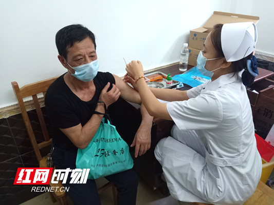新田县人民医院疫苗接种点工作人员蒋苏婷正在为群众注射新冠病毒疫苗.jpg