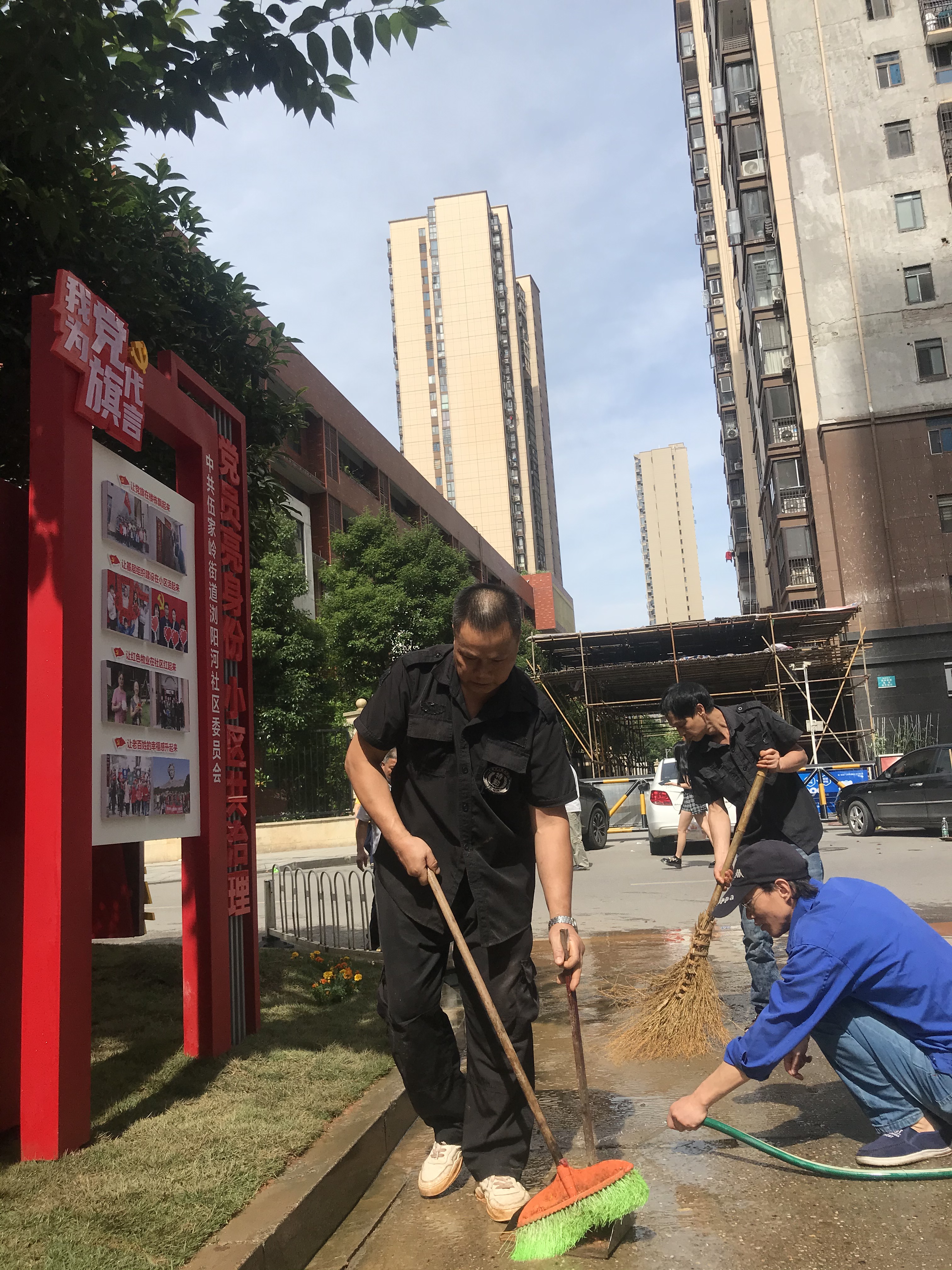 “紅色門牌”立在小區(qū)門口，黨員和物業(yè)服務(wù)人員主動清掃馬路。  長沙晚報(bào)全媒體記者 李卓 攝