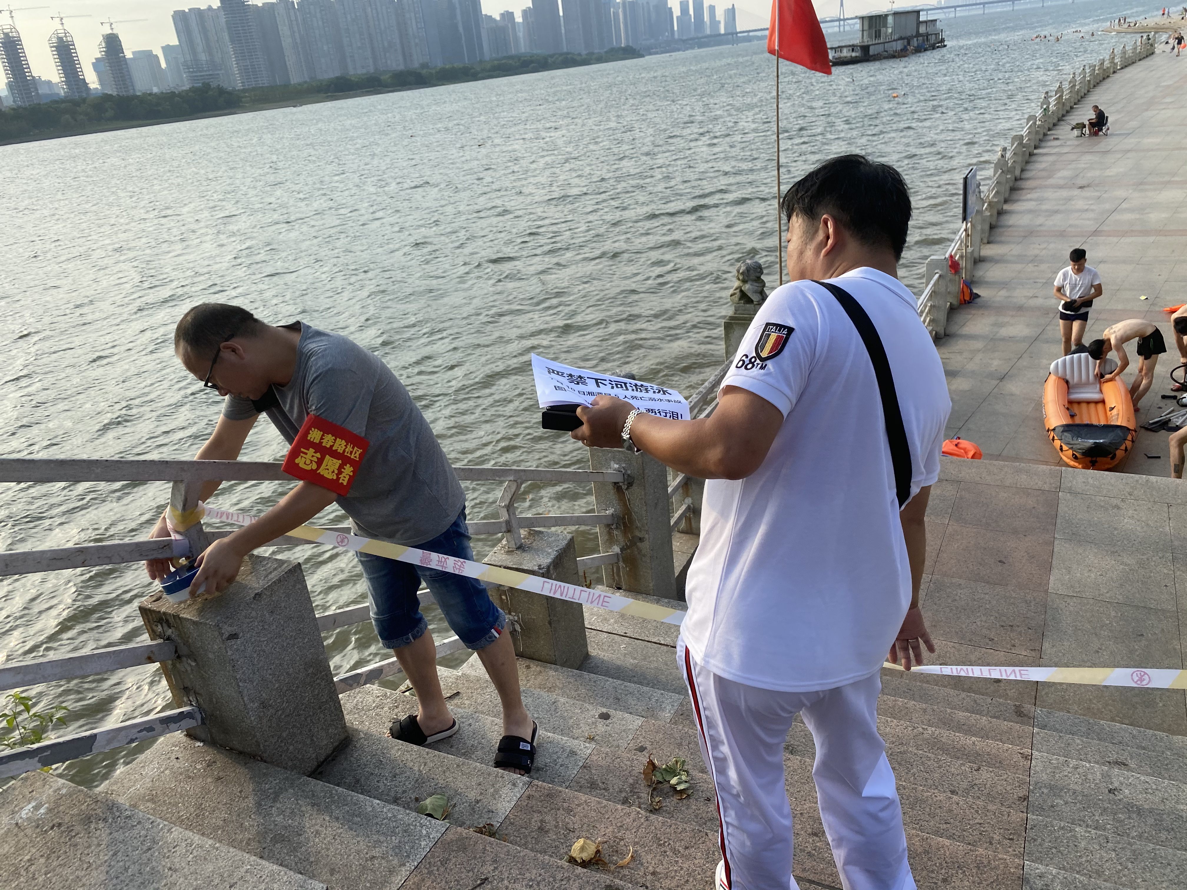 社区志愿者在湘江风光带设置野泳禁区。 通讯员 李文 供图