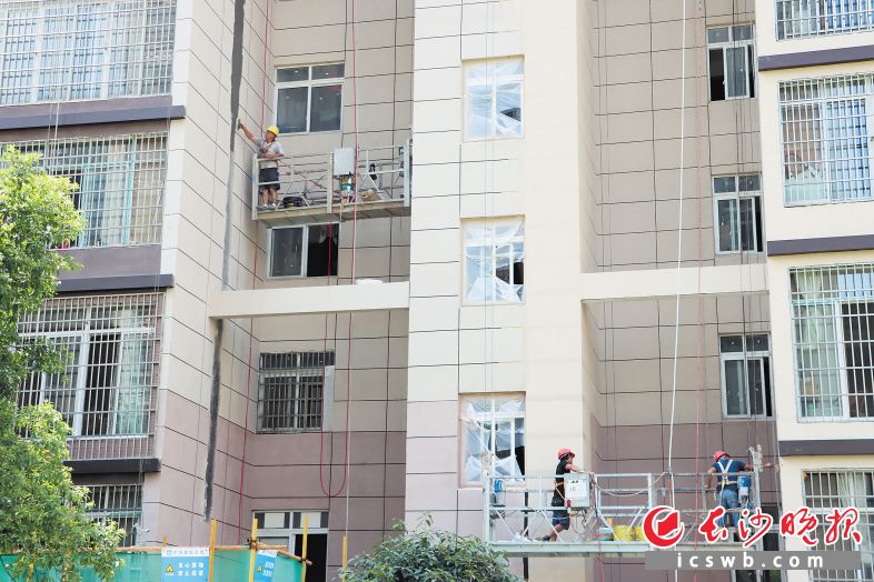 　　烈日当头，工作人员正为洋湖景园小区的楼栋外墙进行防水施工。