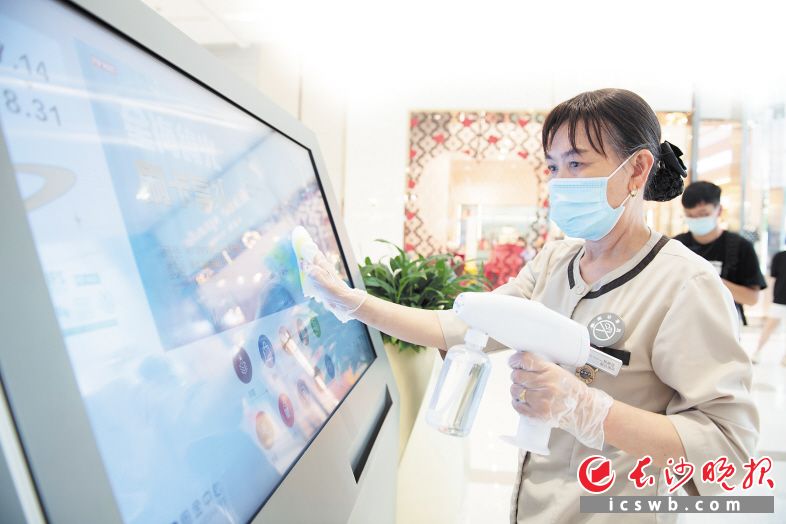 　　↓商场工作人员使用次氯酸消毒机清洁触控屏。