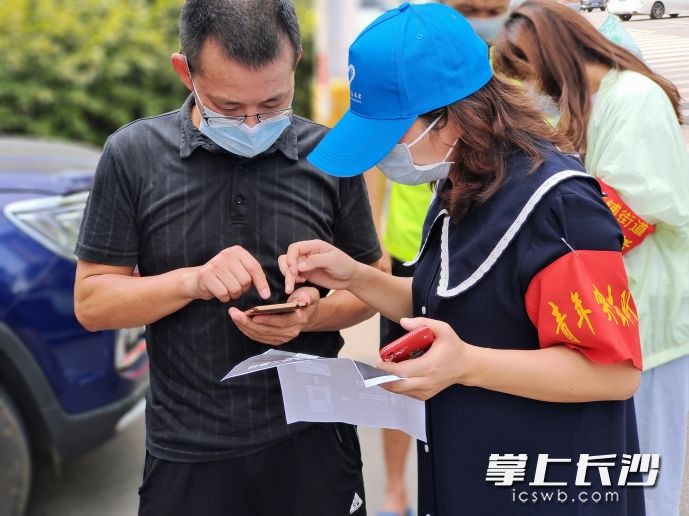 8月3日，新开铺街道豹子岭社区核酸检测点，天心青年志愿者协助市民进行手机注册登记。均为团市委 供图