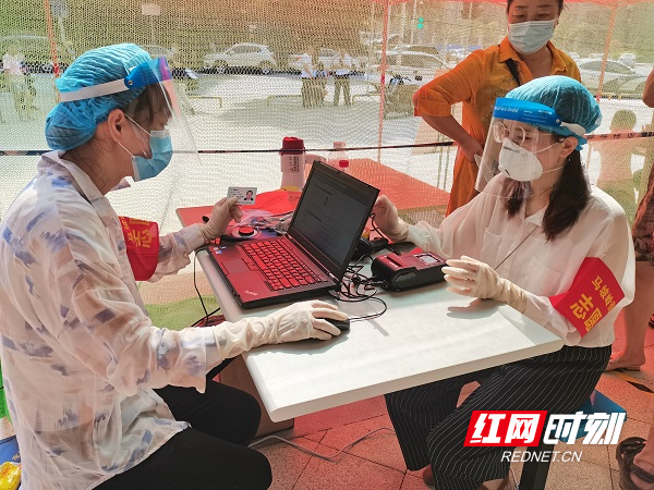 西龙村党员志愿者甘紫微正在核酸采样点录入被采样人信息（右一）.jpg