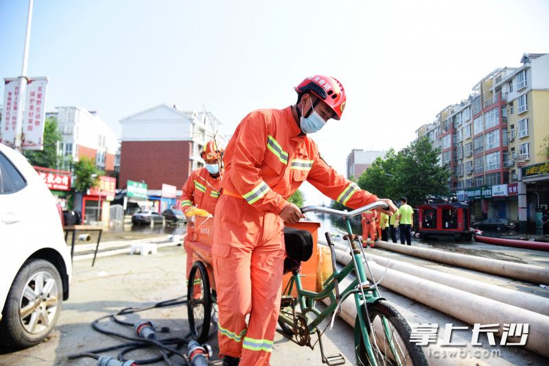 书堂山消防救援站副站长聂嘉利在排涝一线清理积水中的垃圾。长沙晚报全媒体记者 刘琦 摄