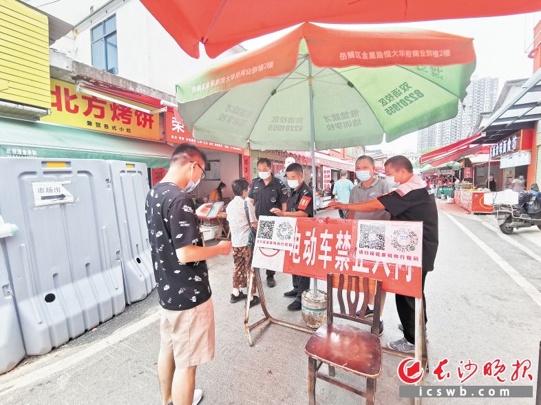 　　在岳麓区含光路滨江综合农贸市场门口，值班保安正在查看买菜市民的健康码。长沙晚报全媒体记者 刘树源 摄