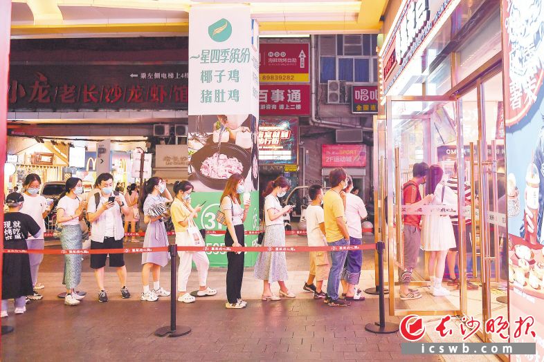 　　15日，市民、游客佩戴口罩排队购买食品。  长沙晚报全媒体记者 郭雨滴 摄