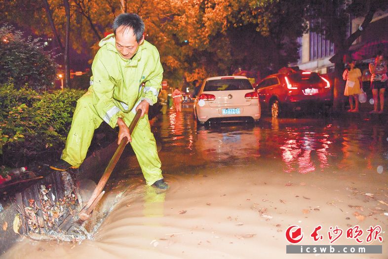 　　18日晚，银杉路谷岳路口，市政工作人员正在清理排水口的垃圾。　　长沙晚报全媒体记者 邹麟 摄