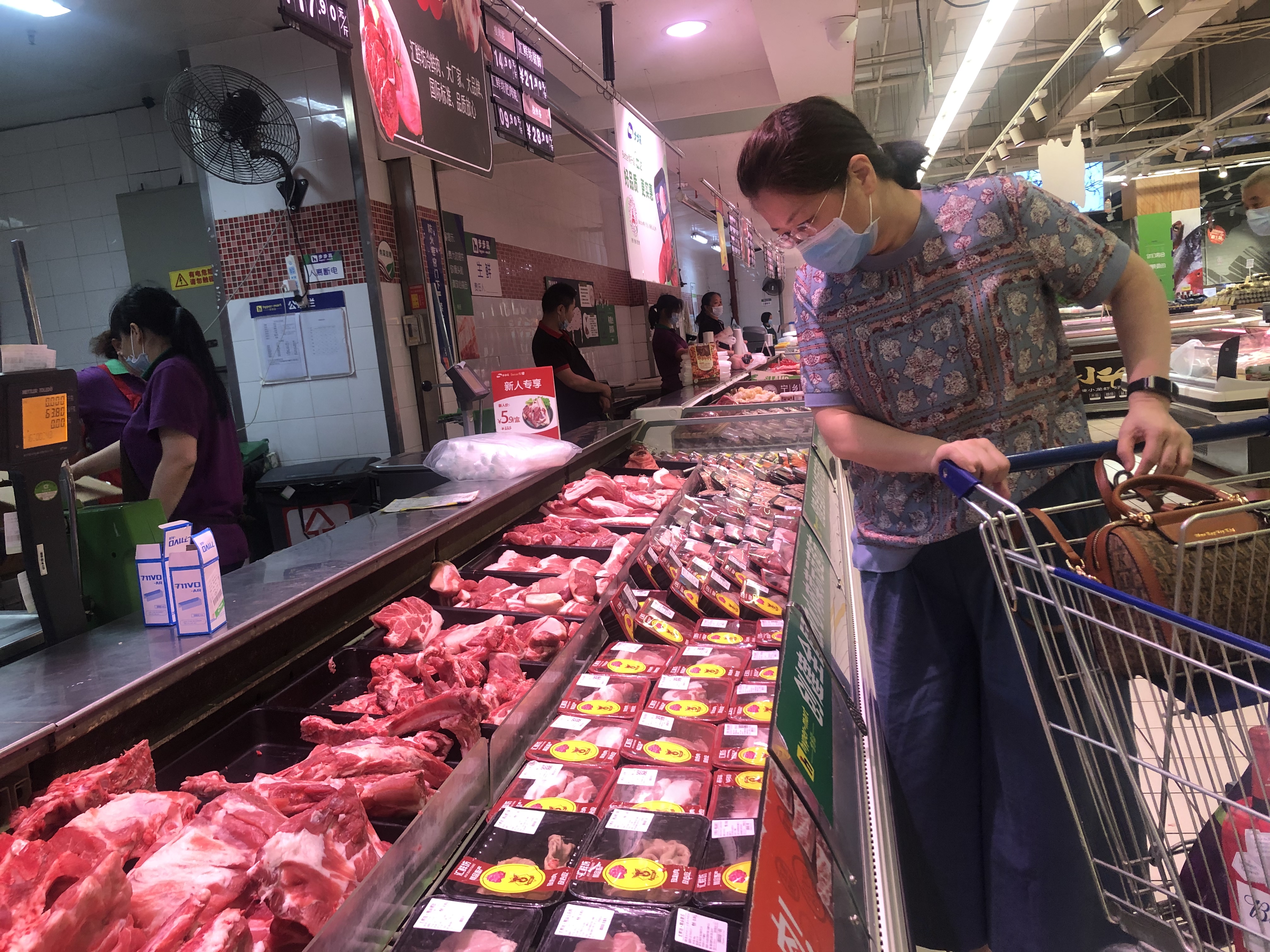 步步高超市内，顾客正在挑选猪肉。