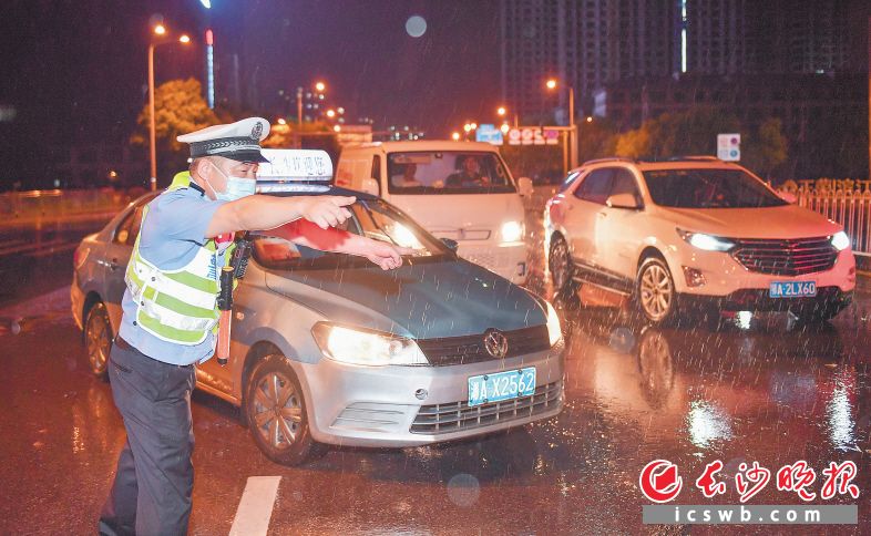 　18日晚，在岳麓区一路面出现短时积水的路段，交警正在紧急疏导交通。长沙晚报全媒体记者 邹麟 摄