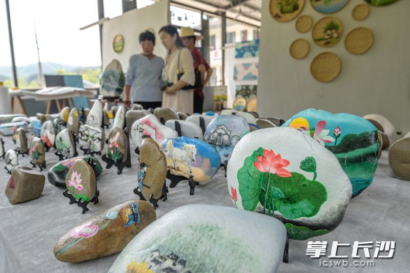 在乌石村的艺术品创作车间，以“荷”为主题的作品或画在石头上，或画在竹簸箕中，富有意趣。