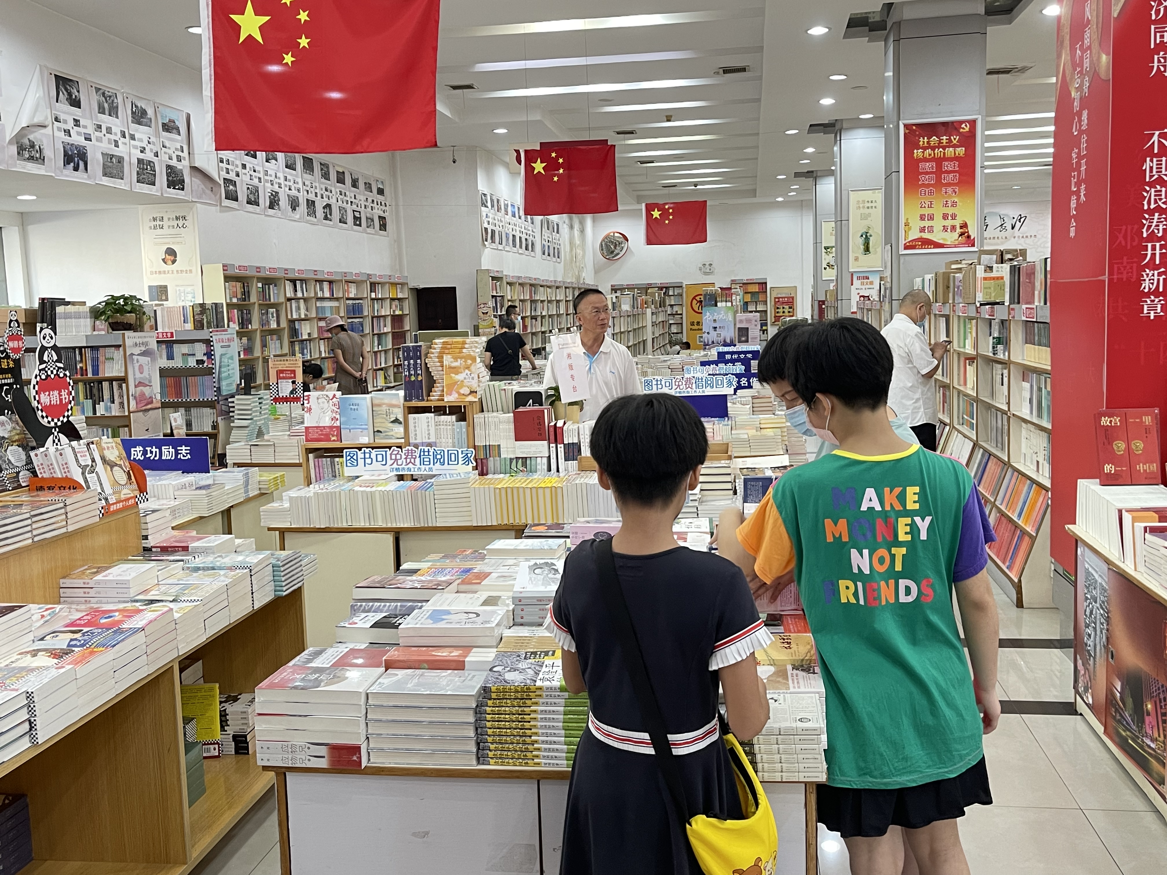 新华书店里，家长带着孩子们正在选购教辅资料和书籍。