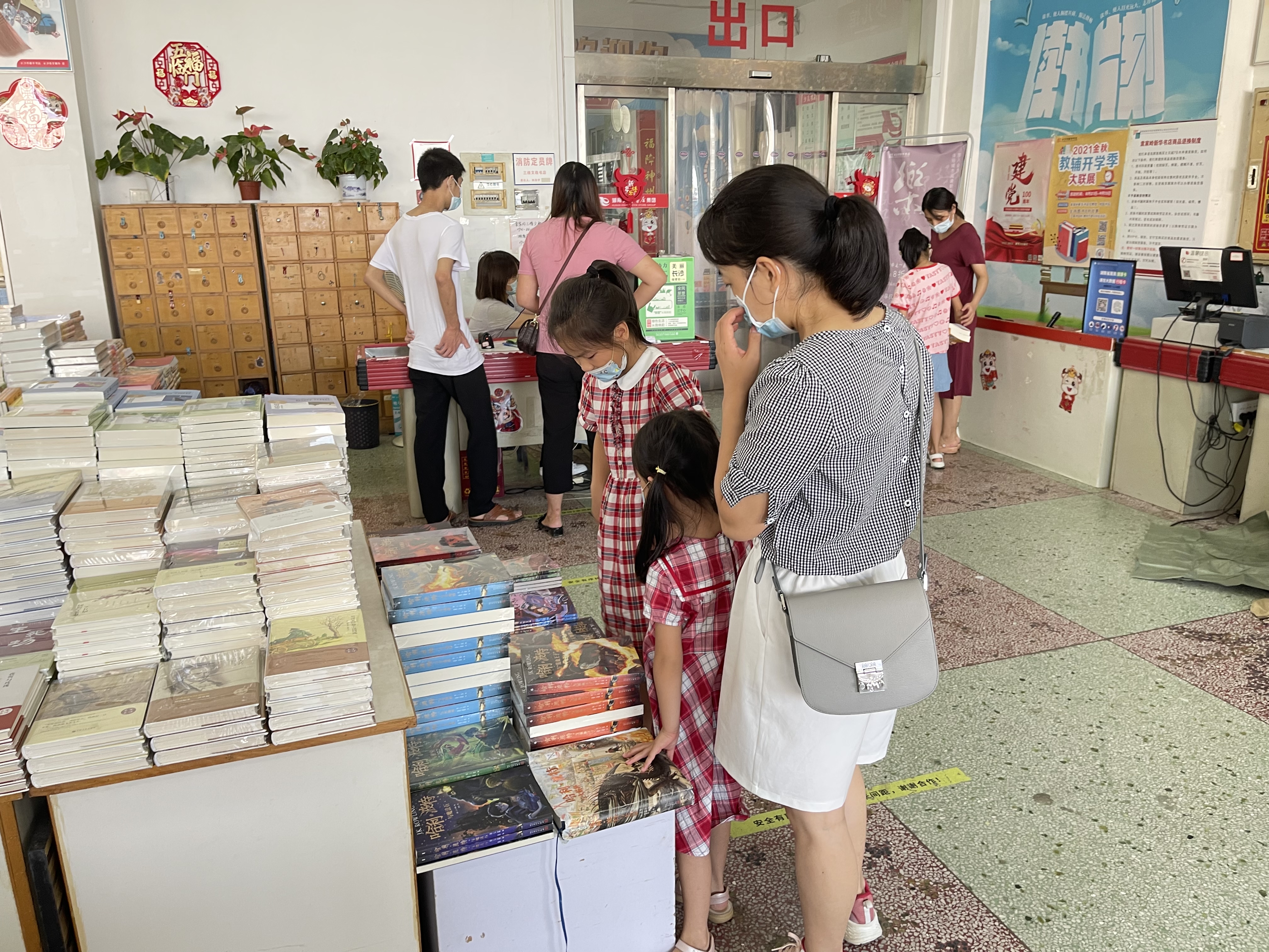 新华书店里，家长带着孩子们正在选购教辅资料和书籍。