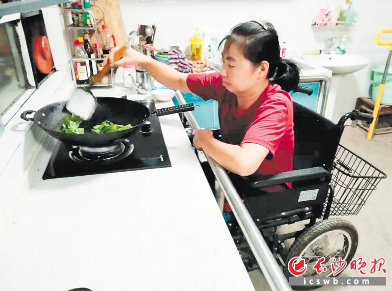　　经过无障碍改造，龙姣坐在轮椅上也能轻松炒菜。长沙晚报通讯员 黄靖康 摄