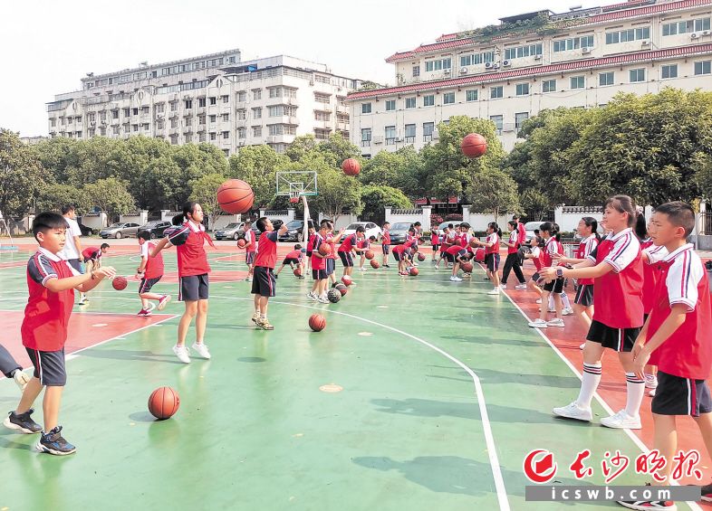 　　新民小学篮球社团的学生们在老师的指导下练习运球。长沙晚报全媒体记者 刘俊 摄