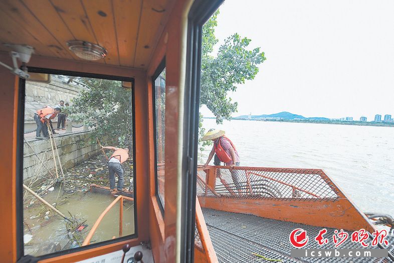 　　环卫工人在降雨后打捞河面上的漂浮垃圾。　　长沙晚报全媒体记者 黄启晴 摄