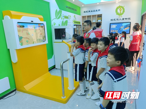图三志愿者在科普体验馆教学生们体验垃圾分类小游戏.jpg