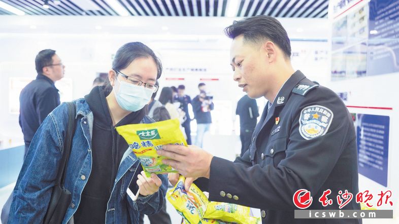 　　公安民警向市民介绍如何辨别真假鸡精。　　长沙晚报全媒体记者 刘晓敏 摄