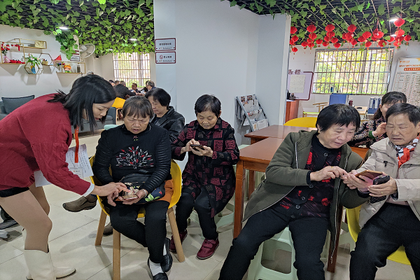 老年居民们正在认真学习手机功能.png