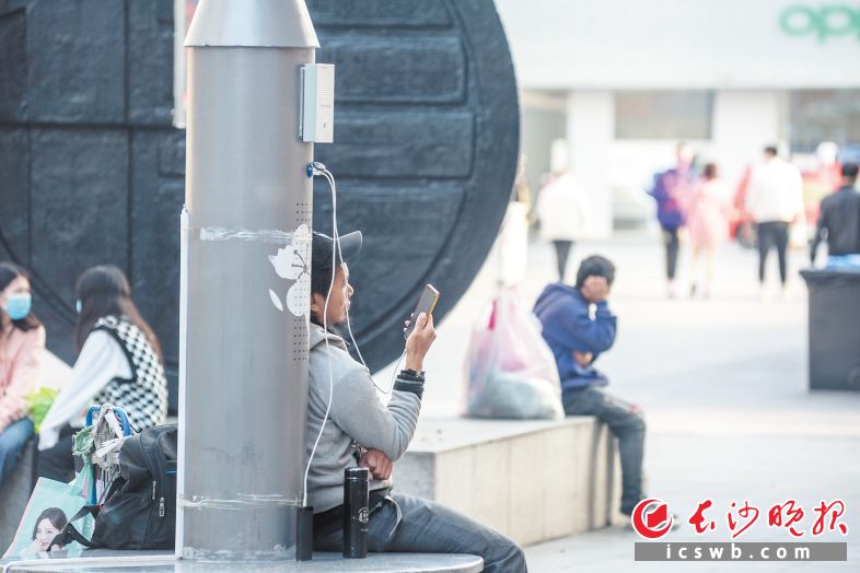 　　步行街多个电线杆上装有手机充电口，方便市民随时可以给手机充电。长沙晚报全媒体记者 陈飞 摄