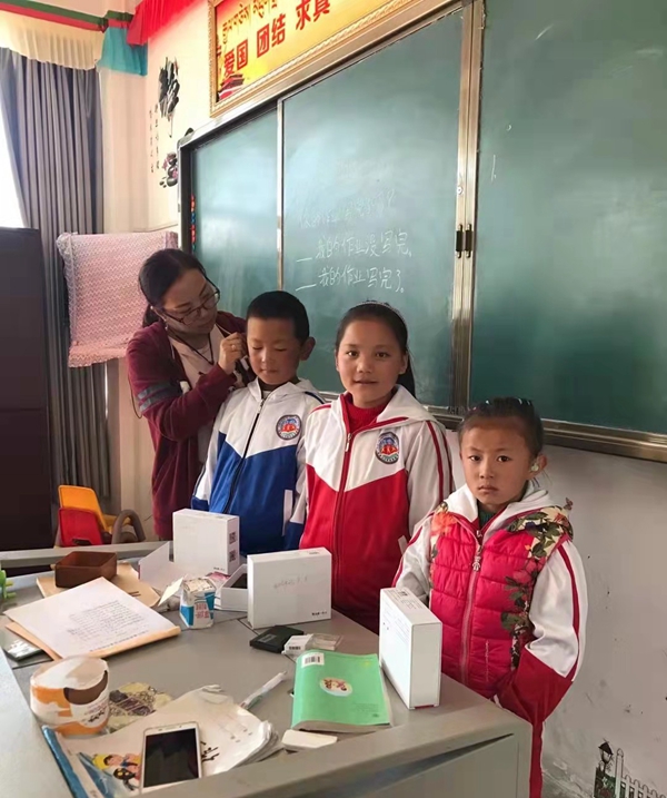 图为次仁拉珍给听障学生试戴助听器。_副本.jpg