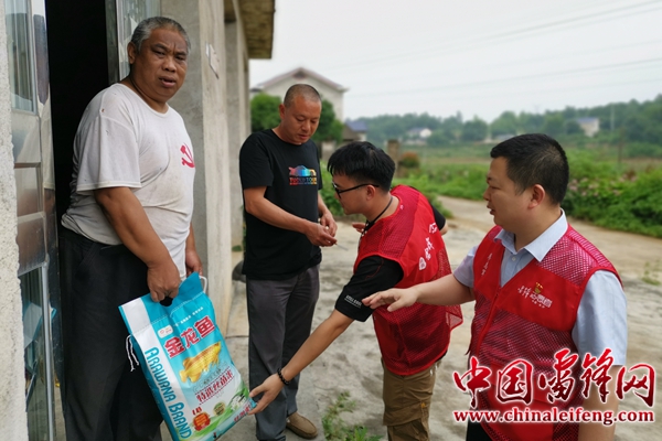 湖南雷锋纪念馆职工代表将认领物资交到困难群众手上。图片来源：湖南雷锋纪念馆 陈慧 摄.jpg